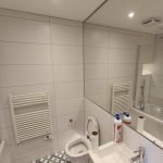 A spotless, professionally cleaned bathroom in a Portsmouth property, featuring a sparkling toilet, descaled sink and taps, gleaming tiles, and polished mirrors, ready for the tenancy inspection.